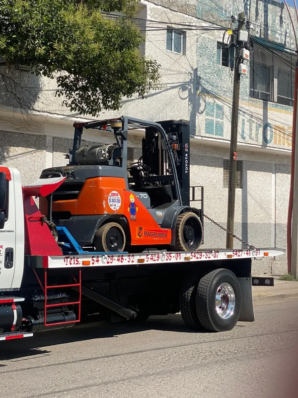 Montacargas asegurado para traslado en plataforma de transporte