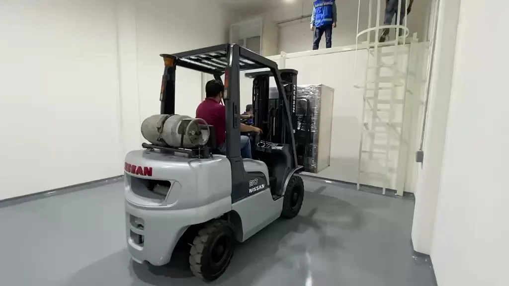 Maniobra de precisión posicionando equipo eléctrico en mezanina industrial